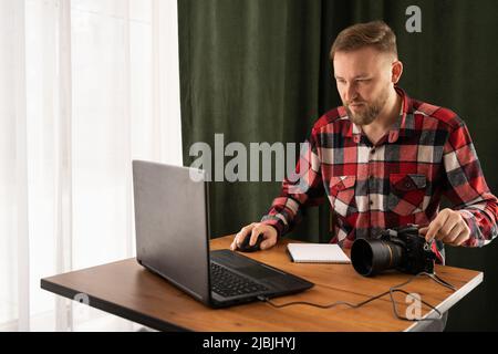 Il fotografo non carica i file sul portatile. Controllo delle foto in ufficio o a casa moderna . Primo piano del fotografo che modifica le sue immagini sul pc Foto Stock