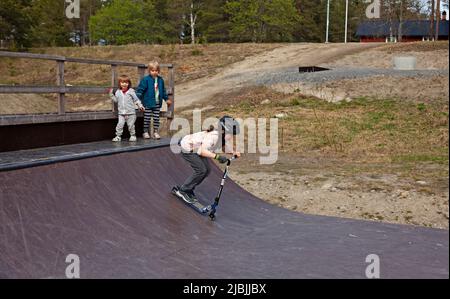 Umea, Norrland Svezia - 20 maggio 2022: kickbike rider sulla rampa per skateboard Foto Stock