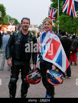 Londra, Grande Londra, Inghilterra, 04 2022 giugno: Concerto Jubilee al Mall. Coppia in bicicletta tiene caschi e indossa una bandiera Union Jack. Foto Stock