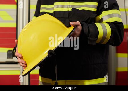 Immagine ravvicinata del casco di un pompiere. Vigile del fuoco con un casco giallo Foto Stock