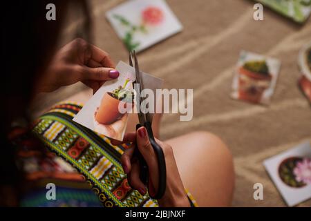 Immagine closeup della donna che taglia fuori l'immagine del cactus quando fa la mappa di desiderio Foto Stock
