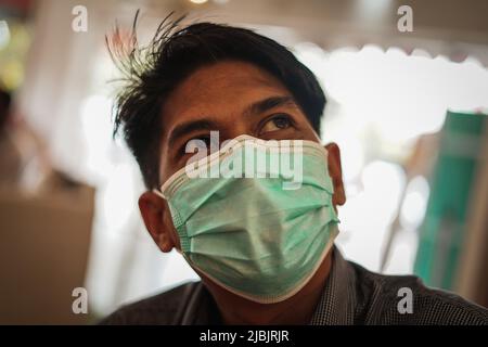 Makassar, Sulawesi meridionale, Indonesia. 7th giugno 2022. Un uomo che indossa una maschera mentre si trova in camera. Il governo indonesiano ha iniziato a rilassarsi e non richiede più l'uso di maschere all'aperto, in linea con la grande percentuale di vaccinazioni in Indonesia. (Credit Image: © Herwin Bahar/ZUMA Press Wire) Foto Stock