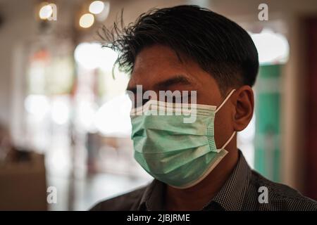 Makassar, Sulawesi meridionale, Indonesia. 7th giugno 2022. Un uomo che indossa una maschera mentre si trova in camera. Il governo indonesiano ha iniziato a rilassarsi e non richiede più l'uso di maschere all'aperto, in linea con la grande percentuale di vaccinazioni in Indonesia. (Credit Image: © Herwin Bahar/ZUMA Press Wire) Foto Stock