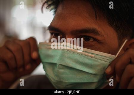 Makassar, Sulawesi meridionale, Indonesia. 7th giugno 2022. Un uomo che indossa una maschera mentre si trova in camera. Il governo indonesiano ha iniziato a rilassarsi e non richiede più l'uso di maschere all'aperto, in linea con la grande percentuale di vaccinazioni in Indonesia. (Credit Image: © Herwin Bahar/ZUMA Press Wire) Foto Stock