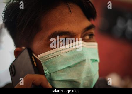 Makassar, Sulawesi meridionale, Indonesia. 7th giugno 2022. Un uomo che indossa una maschera mentre si trova in camera. Il governo indonesiano ha iniziato a rilassarsi e non richiede più l'uso di maschere all'aperto, in linea con la grande percentuale di vaccinazioni in Indonesia. (Credit Image: © Herwin Bahar/ZUMA Press Wire) Foto Stock