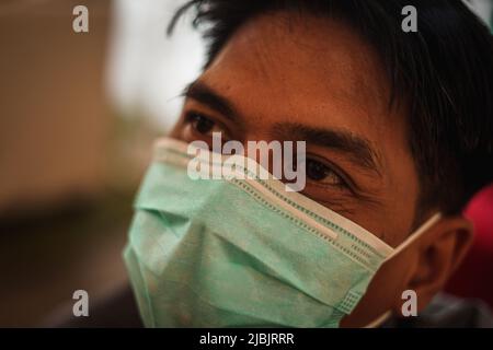 Makassar, Sulawesi meridionale, Indonesia. 7th giugno 2022. Un uomo che indossa una maschera mentre si trova in camera. Il governo indonesiano ha iniziato a rilassarsi e non richiede più l'uso di maschere all'aperto, in linea con la grande percentuale di vaccinazioni in Indonesia. (Credit Image: © Herwin Bahar/ZUMA Press Wire) Foto Stock