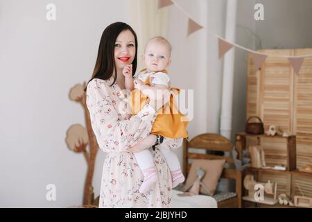 Mamma felice che tiene e abbraccia la figlia piccola, famiglia amorevole sentimenti sinceri. Madre e bambino Foto Stock