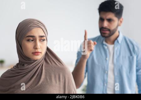 Donna musulmana livisa che tiene carta con testo i'M FINE e suo marito su  sfondo bianco. Concetto di violenza domestica Foto stock - Alamy