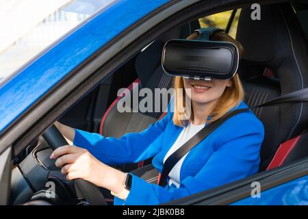 Donna sorridente nel vestito blu seduto in auto con occhiali VR Foto Stock