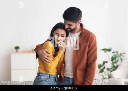 Felice coppia mediorientale che abbraccia Standing in Home Foto Stock