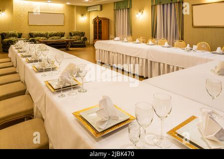 Servito tavolo condiviso nella sala banchetti preparato per il ricevimento di nozze Foto Stock