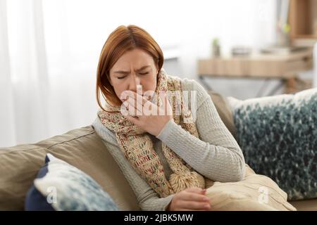 donna malata in sciarpa tosse a casa Foto Stock