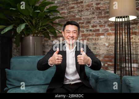 Eccitato giovane uomo d'affari asiatico sensazione felice di ricevere nuova opportunità di lavoro, premio bonus, celebra il concetto di crescita del mercato finanziario stupito uomo shoc Foto Stock
