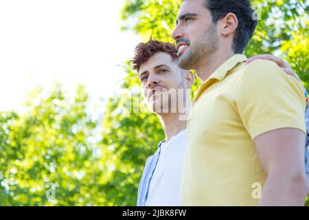 Vista laterale coppia di giovani gay che camminano attraverso un parco. Concetto di rapporto Foto Stock