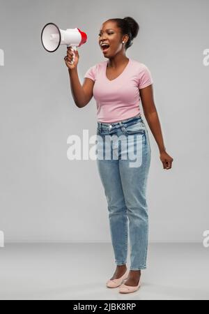 African American donna su sfondo grigio Foto Stock