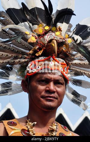 Giacarta, Indonesia - 28 aprile 2013 : l'uomo della tribù Dayak del Borneo, Indonesia, indossa un'attenzione con piume d'aquila e becco di hornbill Foto Stock