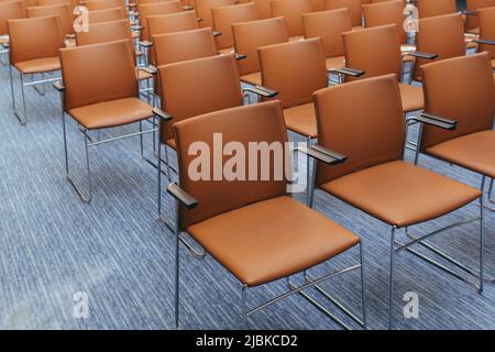 grande sala conferenze vuota con sedie arancioni prima dell'asta Foto Stock