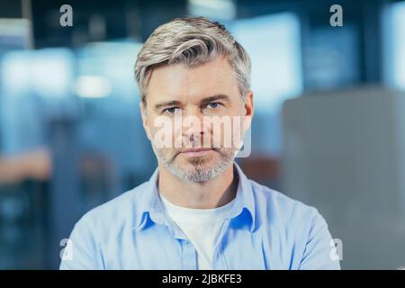 Ritratto di uomo d'affari esperto senior, uomo che guarda con attenzione la foto di primo piano della fotocamera Foto Stock