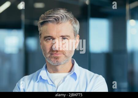 Ritratto di uomo d'affari esperto senior, uomo che guarda con attenzione la foto di primo piano della fotocamera Foto Stock