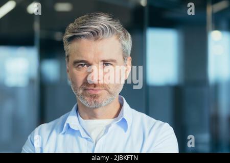 Ritratto di uomo d'affari esperto senior, uomo che guarda con attenzione la foto di primo piano della fotocamera Foto Stock