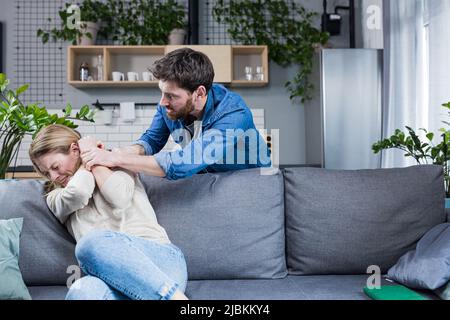Un malvagio marito litigò a casa e batte sua moglie, conflitto di famiglia Foto Stock