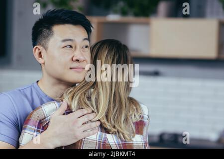 Giovane famiglia multirazziale, foto ravvicinata, uomo e donna abbraccianti, coppia felice sorridente Foto Stock