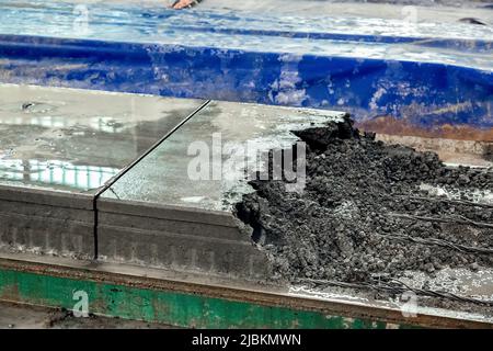 Produzione di solette per pavimenti in calcestruzzo produzione di cemento armato. Casa-costruzione impianto industriale calcestruzzo impianti objets primo piano taglio lastra, nessuno. Foto Stock