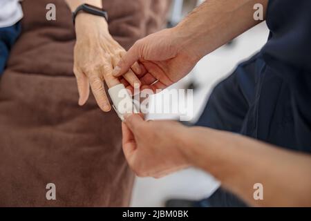 Controllo del personale infermieristico con la saturazione di ossigeno pulsossimetrica del sangue del paziente in ospedale Foto Stock