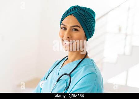 Ritratto di sorridente medico biraciale giovane femmina in hijab in clinica Foto Stock