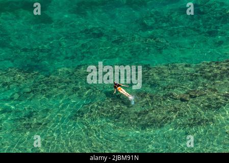 Vista aerea di donne / sirena galleggiante in acque di mare limpide in vacanza Foto Stock