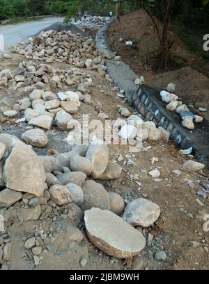 Un mucchio di pietra lungo la strada per la costruzione di un muro di contenimento di pietra per prevenire frane e tagli. Uttarakhand India. Foto Stock