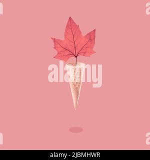 Brillante foglia di acero autunnale in un cono gelato a cialda, concetto di stagione. Foto Stock