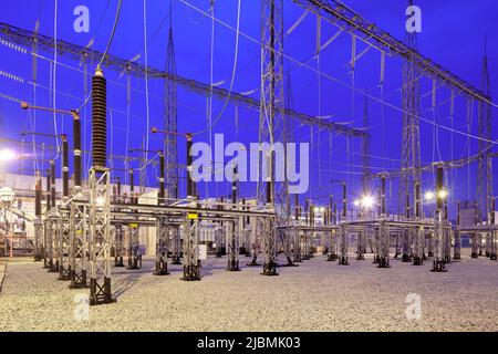 Sottostazione elettrica illuminata al tramonto. Foto Stock