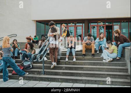 Gli studenti che si riuniscono su passaggi della libreria Foto Stock