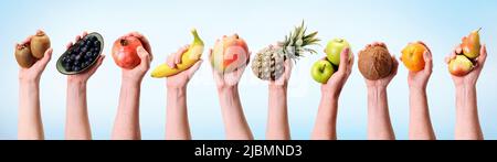 Varie mani che tengono frutta assortita in un formato banner.Banana, ananas, mela e molte altre mani sulla dieta sfondo. Foto Stock