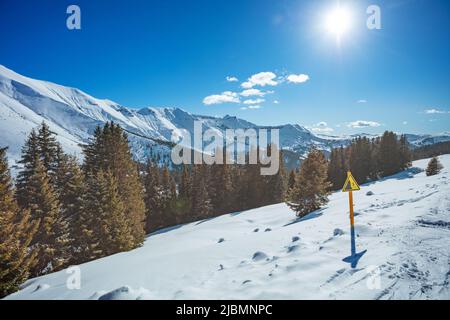 Cartello di pericolo sul lato di una pista di sci di montagna su alte cime Foto Stock