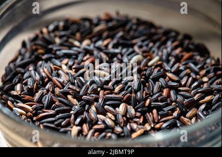 Riso selvatico nero biologico non trasformato in una ciotola. Foto Stock