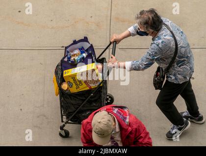 I clienti con i loro carrelli di shopping riempiti di largesse dagli articoli di commercio della dispensa del cibo degli Apostoli santi a Chelsea a New York il mercoledì 1 giugno 2022. (© Richard B. Levine) Foto Stock