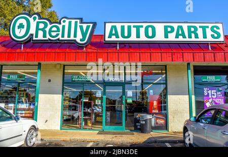 La facciata esterna del negozio o'Reilly Auto Parts e la segnaletica con il logo sono in verde e bianco contro un tetto a coste rosso sopra la parte anteriore di un negozio con vetrine. Foto Stock