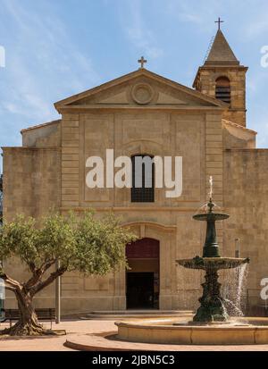 Piazza della Repubblica, la chiesa di Saint Laurent e la sua fontana, a Saint Laurent d'Aigouze, nel Gard, Occitanie, Francia Foto Stock