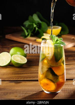 Rinfrescante tè ghiacciato con limone, lime e menta piperita. Spazio di copia. Foto Stock