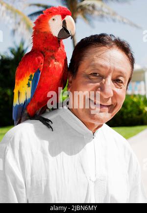 Victor, un istruttore di tai chi, chiama Billy il pappagallo, come parte del rituale di Macaw, uno dei numerosi rituali giornalieri che si svolgono al Live Aqua Resort Foto Stock