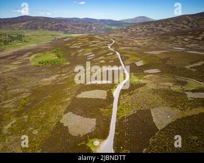 Vista aerea dal drone della strada vuota del B976 che attraversa la brughiera , Old Military Road, a nord di Balmoral in Aberdeenshire Scozia, Regno Unito Foto Stock