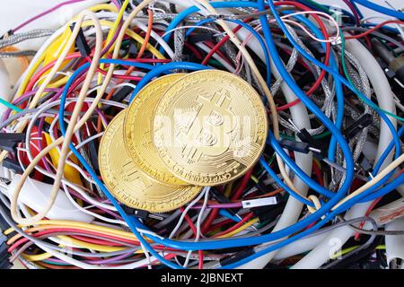 Bitcoins sullo sfondo dei fili colorati del computer in primo piano Foto Stock