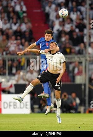 Harry Maguire in Inghilterra (a sinistra) e Thomas Muller in Germania combattono per la palla durante la partita della UEFA Nations League presso l'Allianz Arena di Monaco, in Germania. Data foto: Martedì 7 giugno 2022. Foto Stock