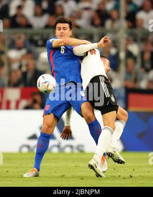 Harry Maguire in Inghilterra (a sinistra) e Kai Havertz in Germania combattono per la palla durante la partita della UEFA Nations League presso l'Allianz Arena di Monaco, in Germania. Data foto: Martedì 7 giugno 2022. Foto Stock