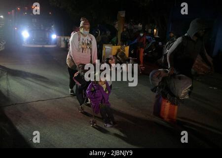 Tijuana, Baja California, Messico. 6th Feb 2022. La domenica si è svolta un'operazione di prima mattina per rimuovere e smantellare il campo migrante al confine con il Chaparral. Il campo contava circa 300 persone che vivevano e dormivano nella zona, alcune dal febbraio dello scorso anno, molte delle quali speravano di ottenere asilo negli Stati Uniti. Le famiglie e gli individui aspettavano di vedere dove andavano, mentre altri lasciavano ai rifugi sparsi per la città. (Credit Image: © Carlos A. Moreno/ZUMA Press Wire) Foto Stock