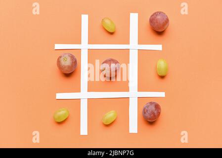 Gioco di Tic-tac-TOE con uve mature su sfondo colorato Foto Stock