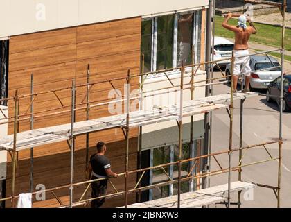 I lavoratori edili senza protezione smantellano il ponteggio di un edificio residenziale di recente costruzione a Sofia, Bulgaria, Europa orientale, Balcani, UE Foto Stock