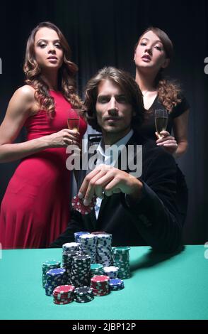 L uomo alla roulette tavolo circondato da belle donne Foto Stock